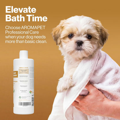 A small fluffy dog wrapped in a white towel on a warm tan background, with a bottle of AROMAPET shampoo shown at lower left and promotional text reading 'Elevate Bath Time.'.