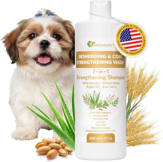 A bottle of Aromapet Deshedding & Coat Strengthening Shampoo shown on a white background with a small dog, aloe leaves, wheat, and peanuts. The bottle is white with gold and brown text, and a gold circular badge claims it is 'FORMULATED IN THE USA'.