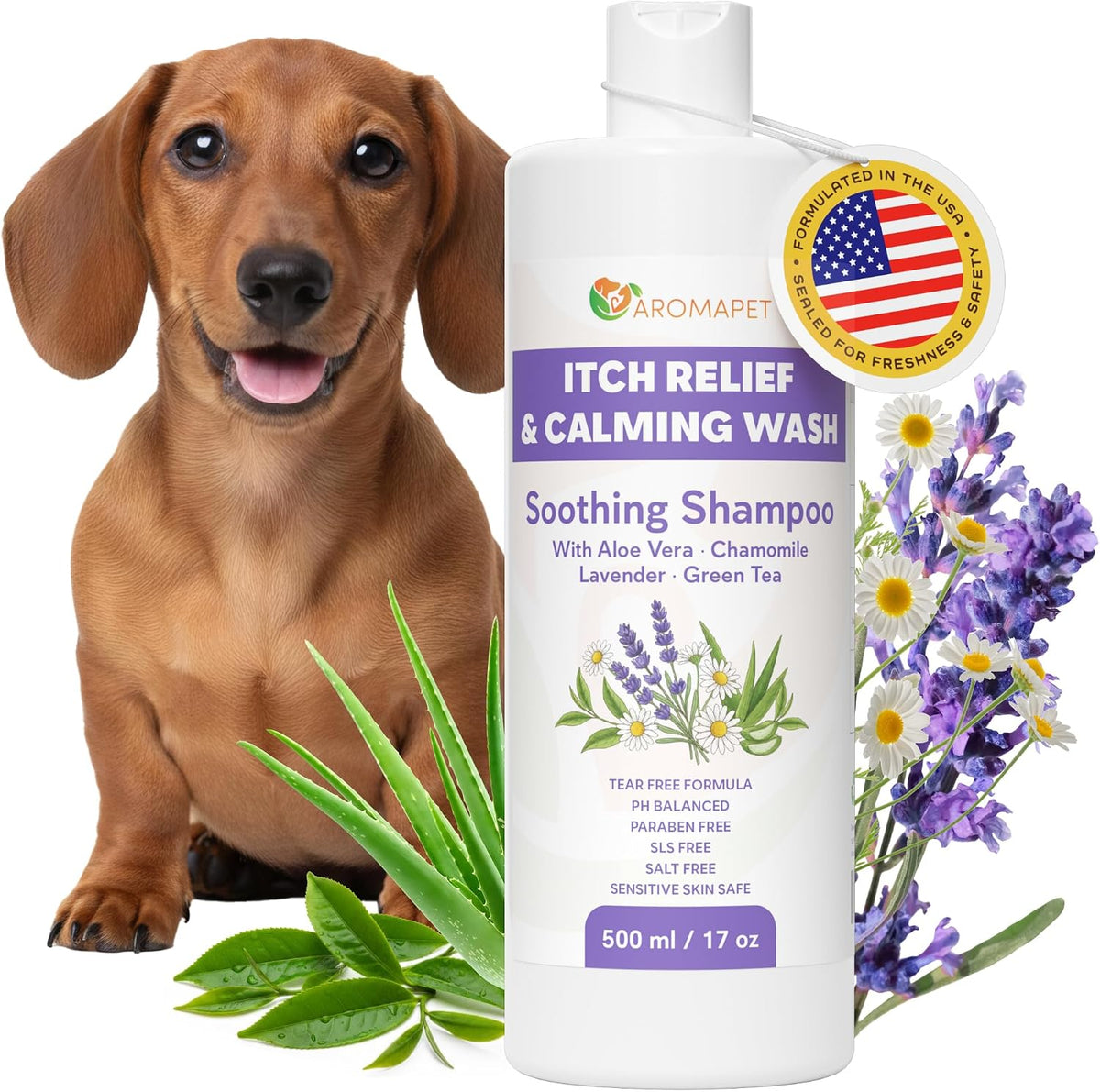 A bottle of Aromapet Itch Relief & Calming Wash Soothing Shampoo stands on a white background with a dachshund dog on the left and lavender flowers and green leaves on the right. The bottle is white with purple text and a circular American flag badge.